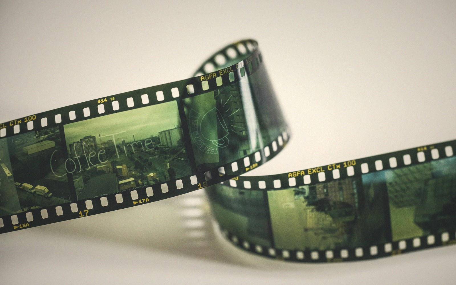 A curled strip of 35mm negative film with visible city photo frames